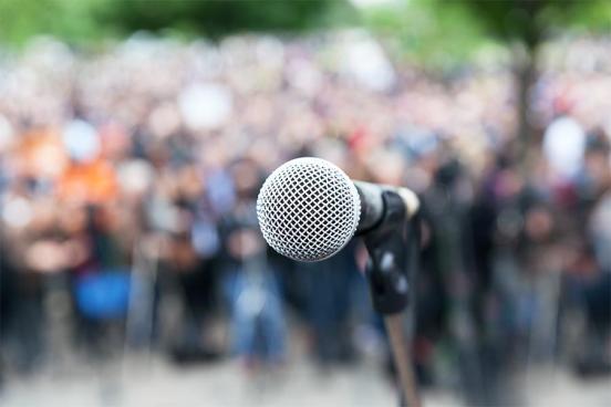 A microphone is seen set up before a crowd