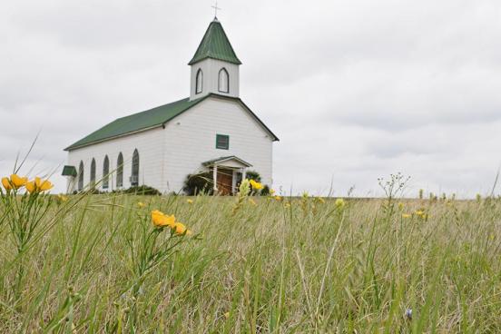 A rural church is seen in a field