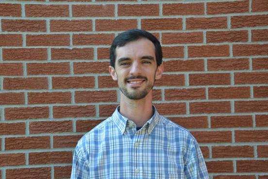 John Kluge in front of a brick wall