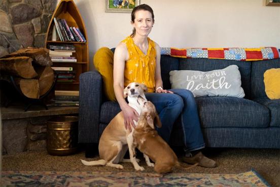 Jessica Bates sits on the couch with her dogs