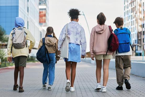 Kids walking on the sidewalk with backpacks