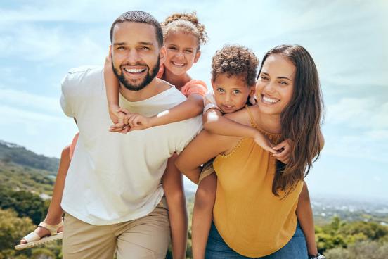 Family with parents carrying their son and daughter on their backs