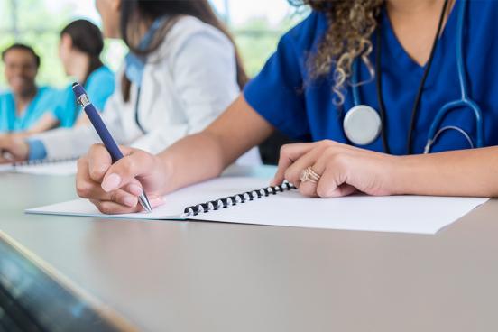 Medical student writing in a notebook