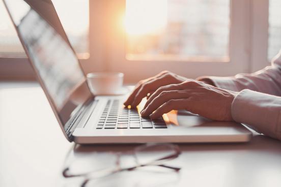 A man types on a laptop keyboard