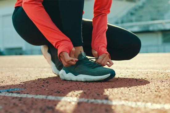 Female track athlete tying her shoes