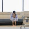 Woman sitting on a couch in a hospital gown