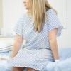 Woman sitting on a bed in a hospital gown