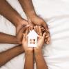 Hands holding a house symbolizing foster care