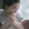 Mother kissing baby's hand