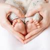 baby feet surrounded by hands shaped like a heart