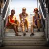 Selina Soule, Chelsea Michell, and Alanna Smith sitting on bleacher stairs