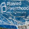 A Planned Parenthood banner on a chain link fence