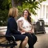 Kristen Waggoner and Lorie Smith sit on a bench outside of the Supreme Court building in Washington, D.C.