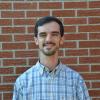 John Kluge in front of a brick wall