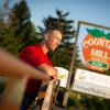 Steve Tennes of Country Mill Farms stands in front of his family farm's sign