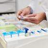 A pharmacist looks at prescriptions in a drawer