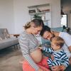 A toddler with his parents touches his mother's pregnant belly