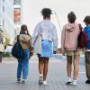 Kids walking on the sidewalk with backpacks