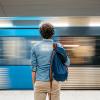 A man stands at a train station as a train goes by